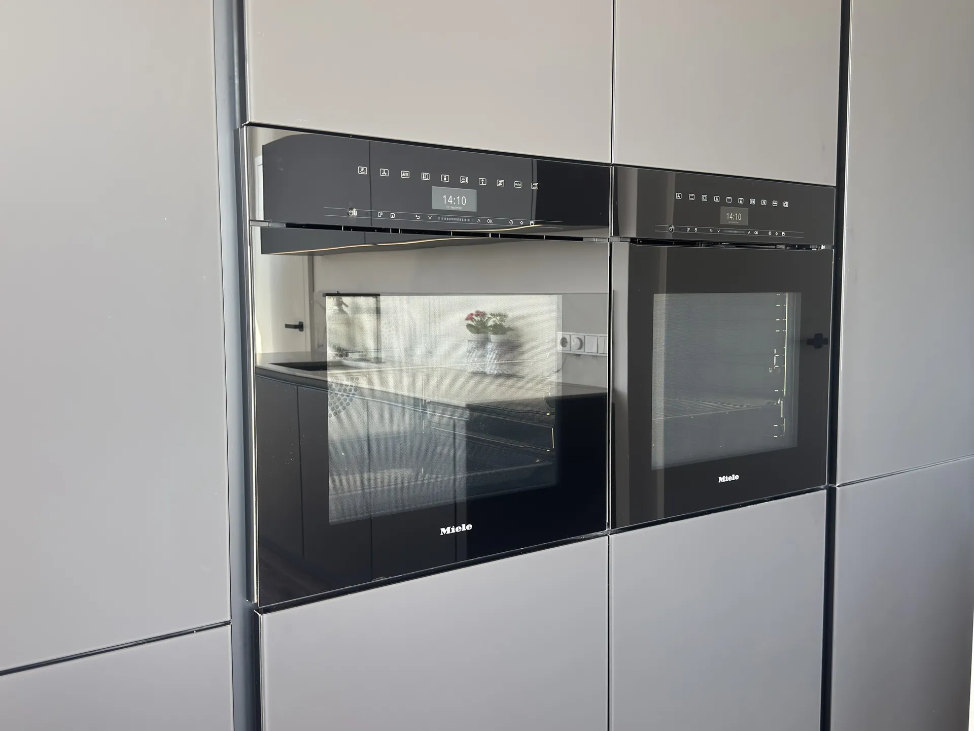 Kombi-Dampfgarer und Backofen von Miele nebeneinander in der Hochschrankwand – Penthouse in Wels