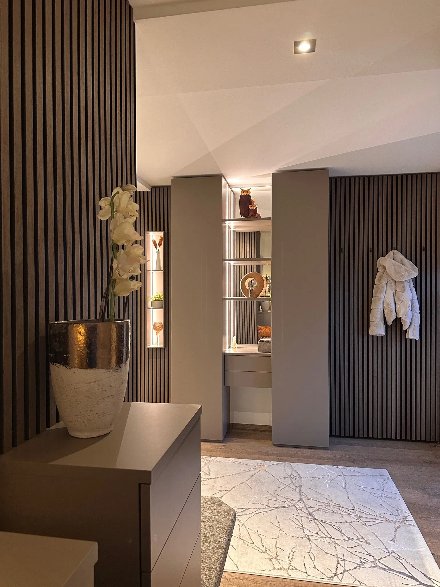 Warme Töne für ein Zuhause in Bad Hall – Lamellenwand und Nische
