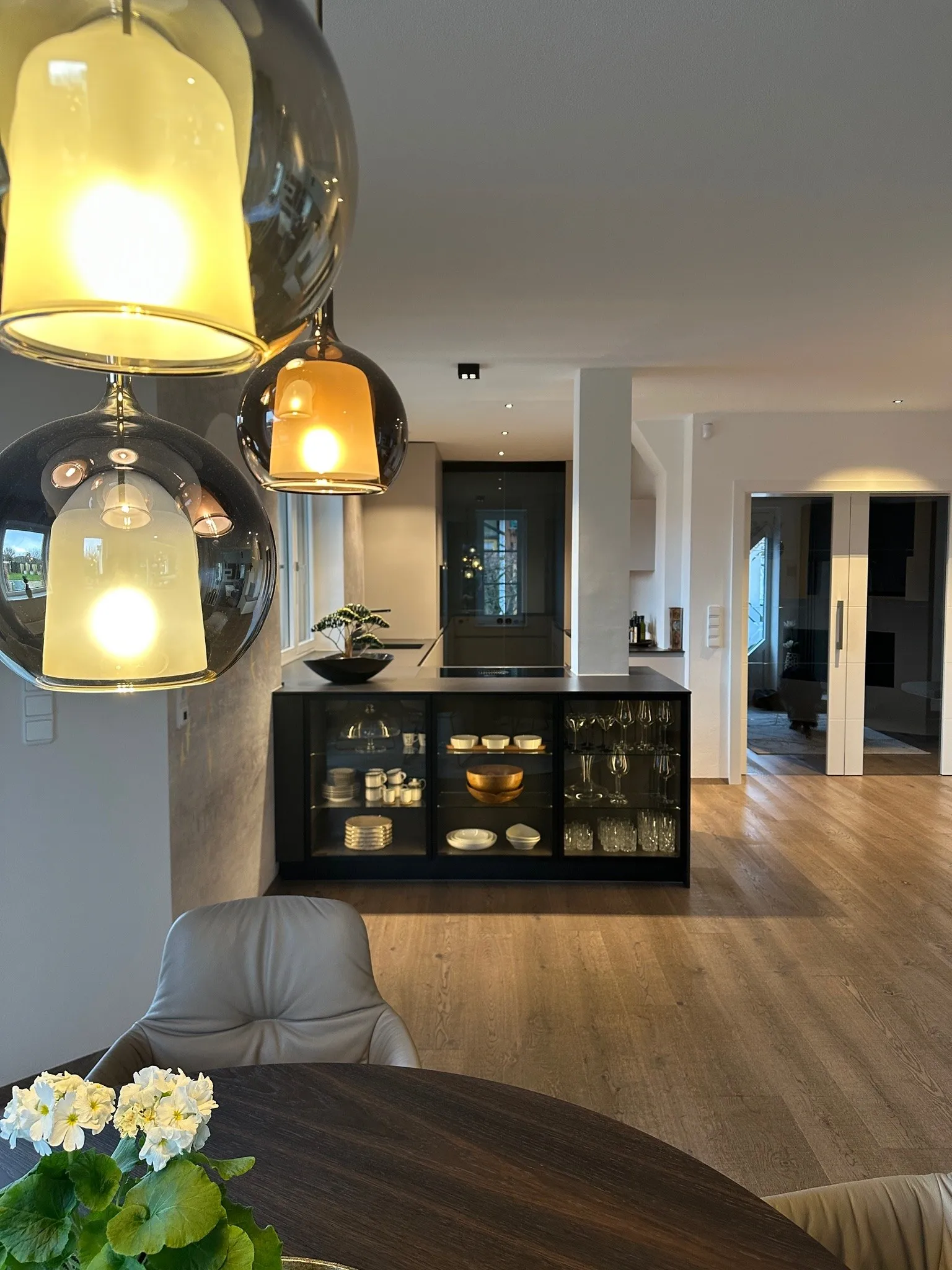 Warme Töne für ein Zuhause in Bad Hall – Wohnraum Küche Glasvitrine