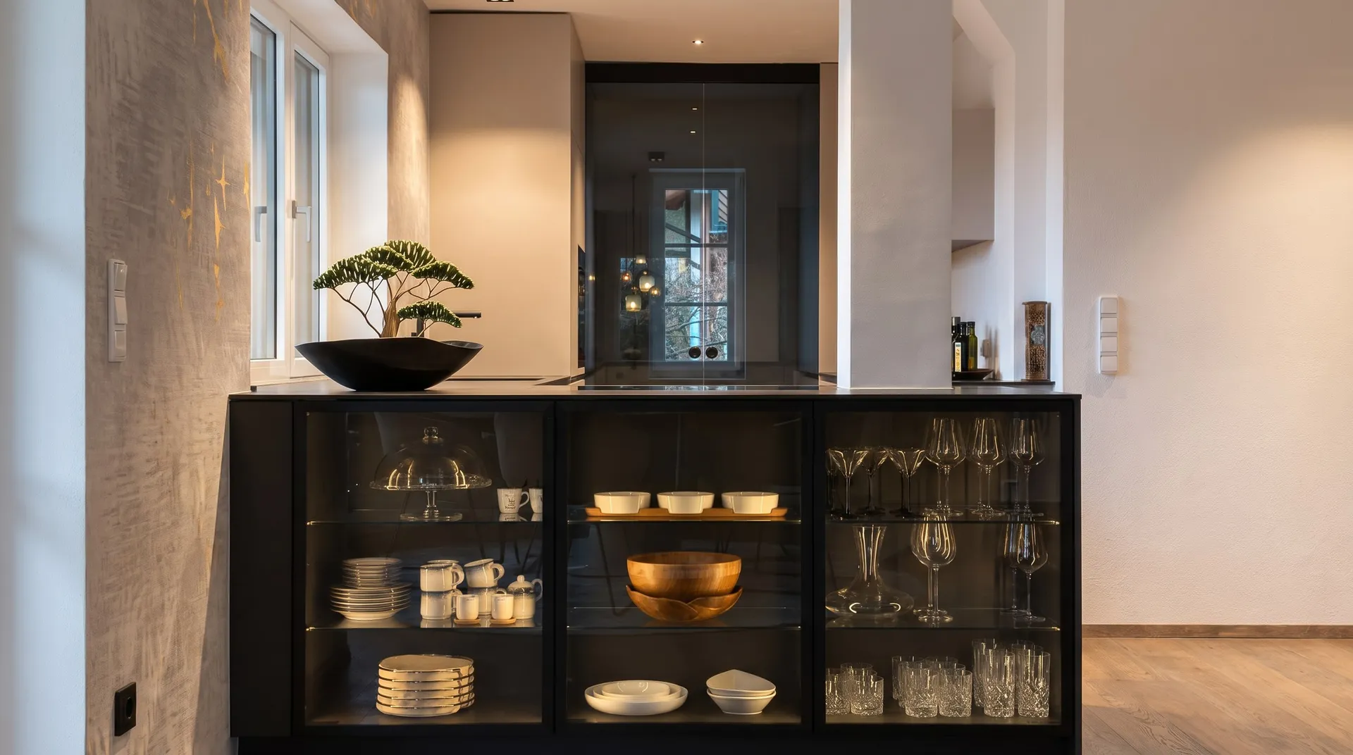 Küche mit beleuchteter Glasvitrine und getönter Schiebetür – Projekt in Bad Hall